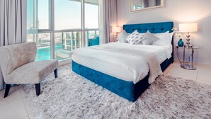 A modern hotel room with a large bed, a chair, and a view of the city. - Elite Royal Apartment - Burj Khalifa & Fountain view - Grand (Dubai)