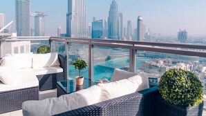 Un lounge sul tetto con vista sullo skyline urbano, che include grattacieli e una piscina.