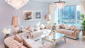 A spacious living room with a large window offering a city view, a chandelier, and a modern coffee table. - Elite Royal Apartment | Burj Khalifa & Fountain view | Star (Dubai)