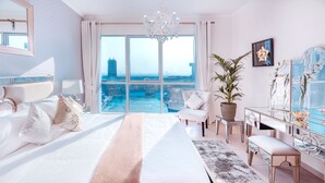 A spacious bedroom with a large bed, a sitting area, and a view of the city. - Elite Royal Apartment - Burj Khalifa & Fountain view - The Royal (Dubai)