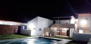 A modern house with a swimming pool, a covered patio, and a staircase leading to the upper floor. - Hôtel Naell Assinie (Assinie)
