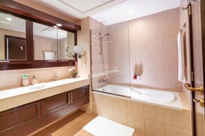 Ein modernes Badezimmer mit einer Duschkabine, einem großen Spiegel und einer Badewanne.