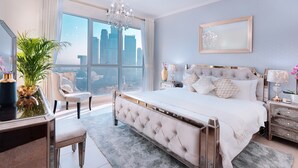 A spacious bedroom with a large bed, a sitting area, and a view of a cityscape. - Elite Royal Apartment - Burj Khalifa & Fountain view - Royal (Dubai)