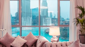 Una habitación lujosa con un ventanal grande que ofrece vistas a un horizonte urbano y una extensión de agua.