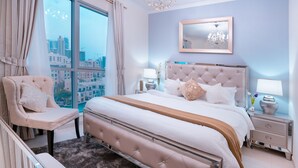 Un dormitorio con una cama grande, una silla, una mesita de noche, un espejo y vistas a la ciudad.