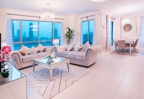 Relax in this stylish living room with a city view, featuring a sofa, dining area, and potted plant.