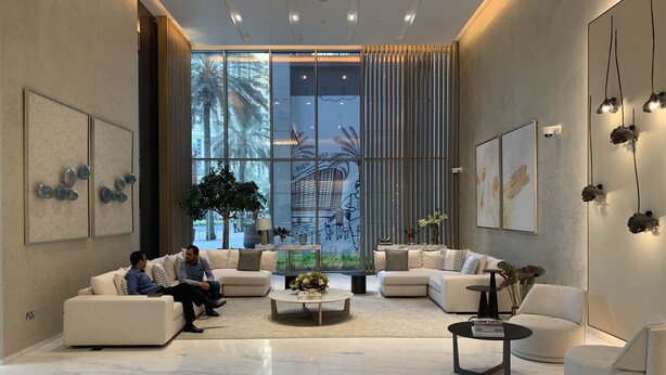 Eine moderne Lobby mit Sitzgelegenheiten, großen Fenstern und Kunstwerken an den Wänden.