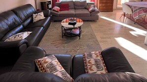 A living room with a sofa set, a coffee table, and a dining area with a table and chairs. - COMFORTABLE 4/5-ROOM APARTMENT IN SECURE RESIDENCE WITH SWIMMING POOL (Saint-Raphaël)