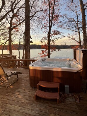 A hot tub on a wooden deck with a view of a lake and trees. - Lakefront.AmazingView.HotTub.BoatRentalOption (Lake Ozark)