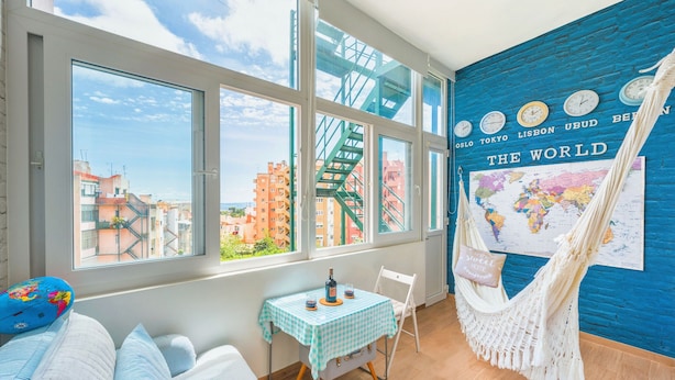 A room with large windows, a hammock, a table with a map, and a bed with striped bedding. - Family Dream | A/C | Balcony & View | Lofts | Desk (Lisboa)