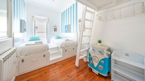 A bedroom with two beds, a dresser, a vanity, and a blue and white vintage-style dresser. - Family Dream | A/C | Balcony & View | Lofts | Desk (Lisboa)