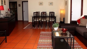 Un salon comprenant un coin repas, un canapé, une table basse et une cheminée.