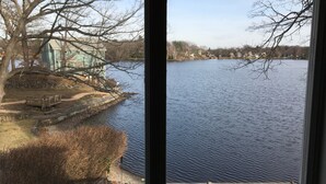 Blick auf einen See vom Fenster aus, einschließlich einer Anlegestelle und einem Gebäude mit einem grünen Dach.