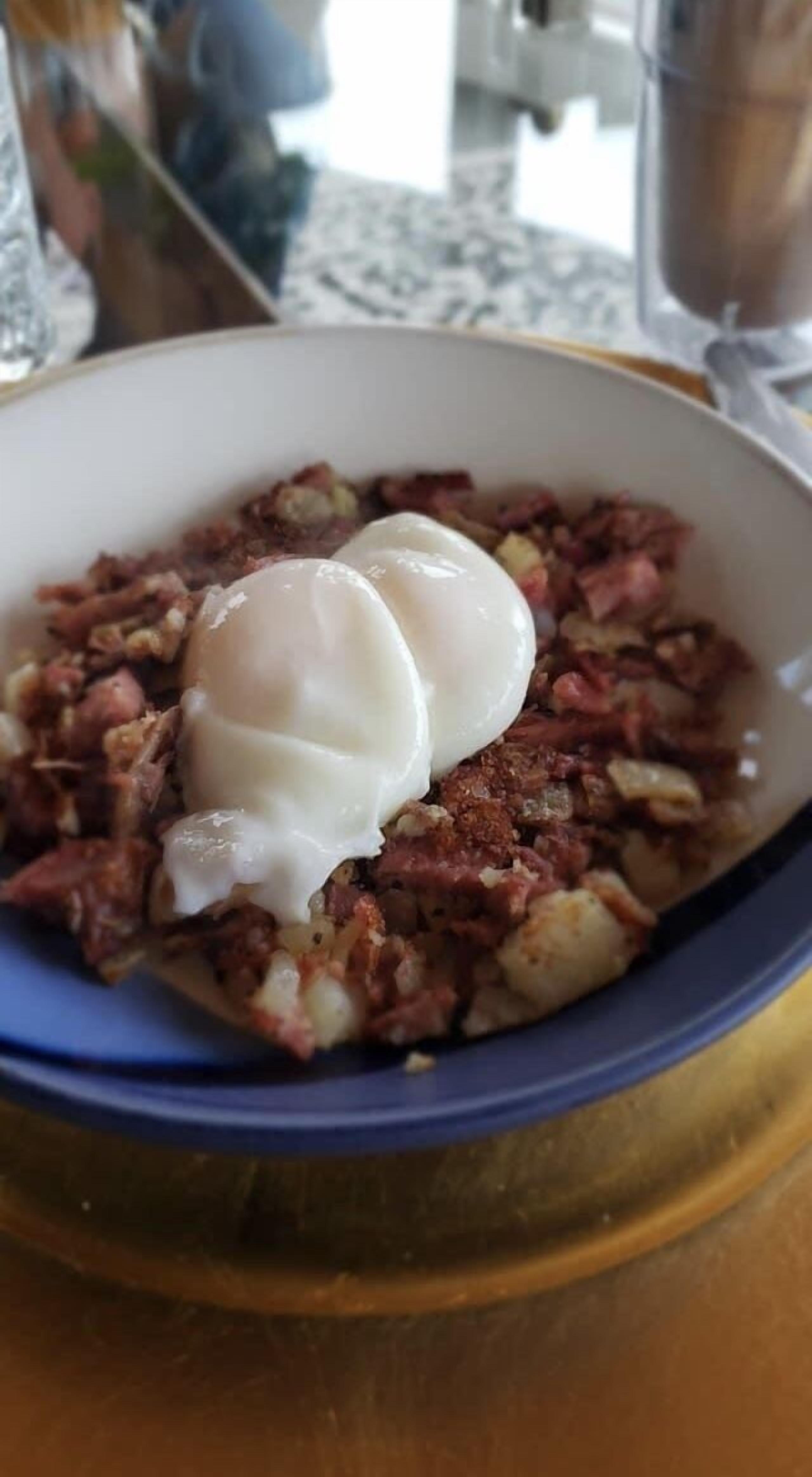 A bowl of food with a poached egg on top.