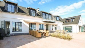 A two-story house with a covered patio area, outdoor seating, and a swimming pool. - Awesome home in Brantevik with sauna (Brantevik)