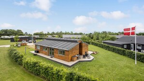 A modern building with a flat roof, surrounded by well-maintained grass and hedges. - Amazing home in Odder with kitchen (Odder)