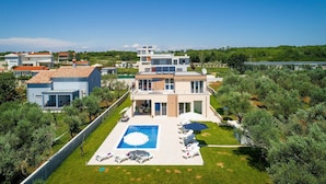 A modern multi-story residential building with a swimming pool and outdoor seating area. - Gorgeous home in Vodnjan (Vodnjan)