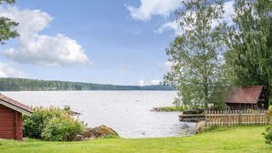 A lakeside cabin with a wooden deck and a view of the lake. - Lovely home in Idkerberget (Idkerberget)