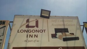 A billboard for Longonot Inn advertising self-contained accommodation with a bed and a nightstand. - Longonot Inn (Mai Mahiu)