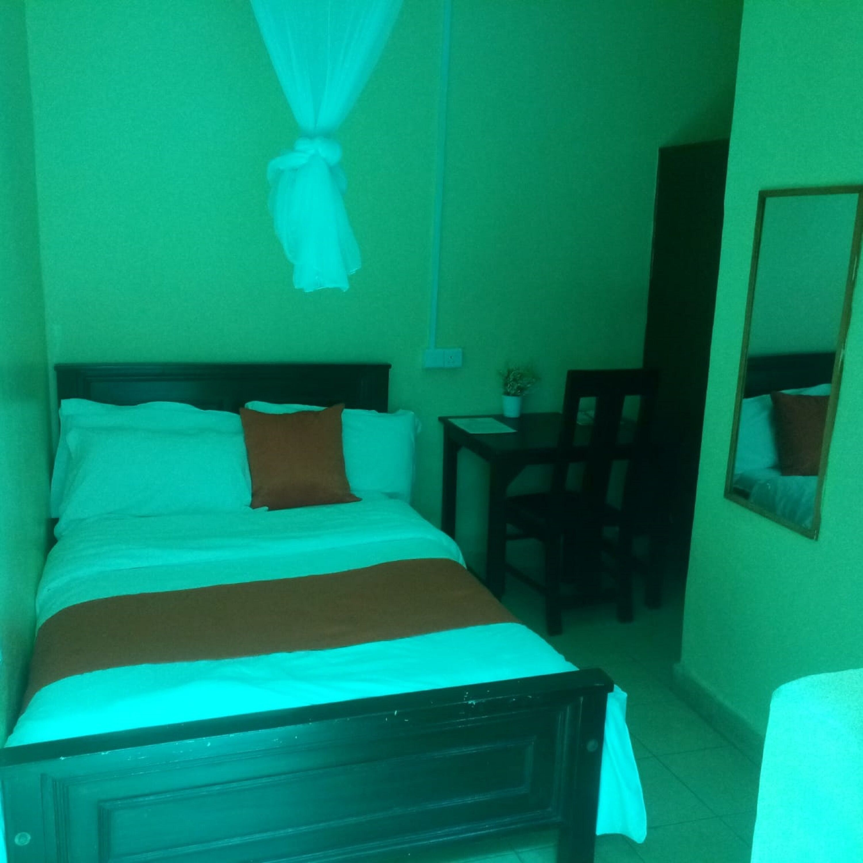 A room with a bed, a desk, and a chair.