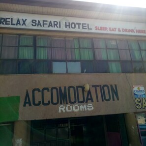 A building with a sign for 'RELAX SAFARI HOTEL' and 'ACCOMODATION ROOMS'. - Relax Safari Hotel (Nairobi)