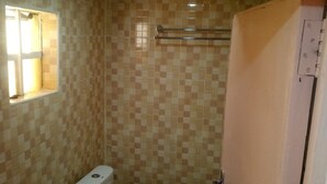 A small bathroom with a toilet, bidet, and a window. - Serene Gates Guest House (Mai Mahiu)