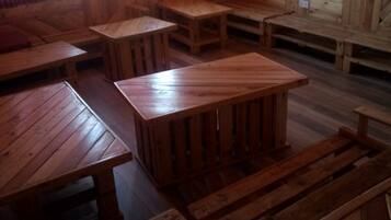 A rustic wooden interior with benches and tables arranged for seating.