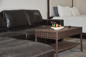 A dark brown leather sofa and a wicker coffee table with a bowl of fruit and a remote control. - Your Home away from home (Miami)
