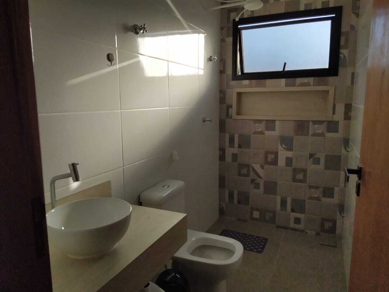 Une salle de bain avec un grand lavabo blanc, des toilettes et un espace douche.