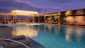 A pool area with lounge chairs and a bar. - Hotel Okura Manila at Newport World Resorts (Pasay)