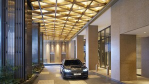 A modern building with a car parked in the entrance. - Hotel Okura Manila at Newport World Resorts (Pasay)