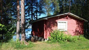 A small red cabin with a window, surrounded by trees and grass. - Raanumökki 4 by Interhome (Pello)