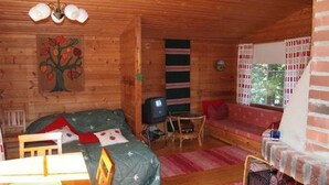 A cozy cabin room with a bed, a desk, and a TV. - Raanumökki 4 by Interhome (Pello)