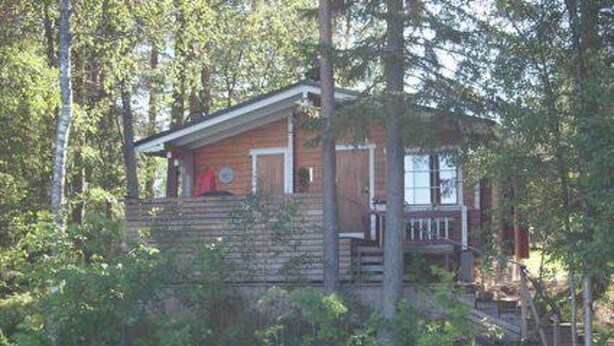 A cabin surrounded by dense forest, with a wooden exterior and a small porch. - Raanumökki 4 by Interhome (Pello)