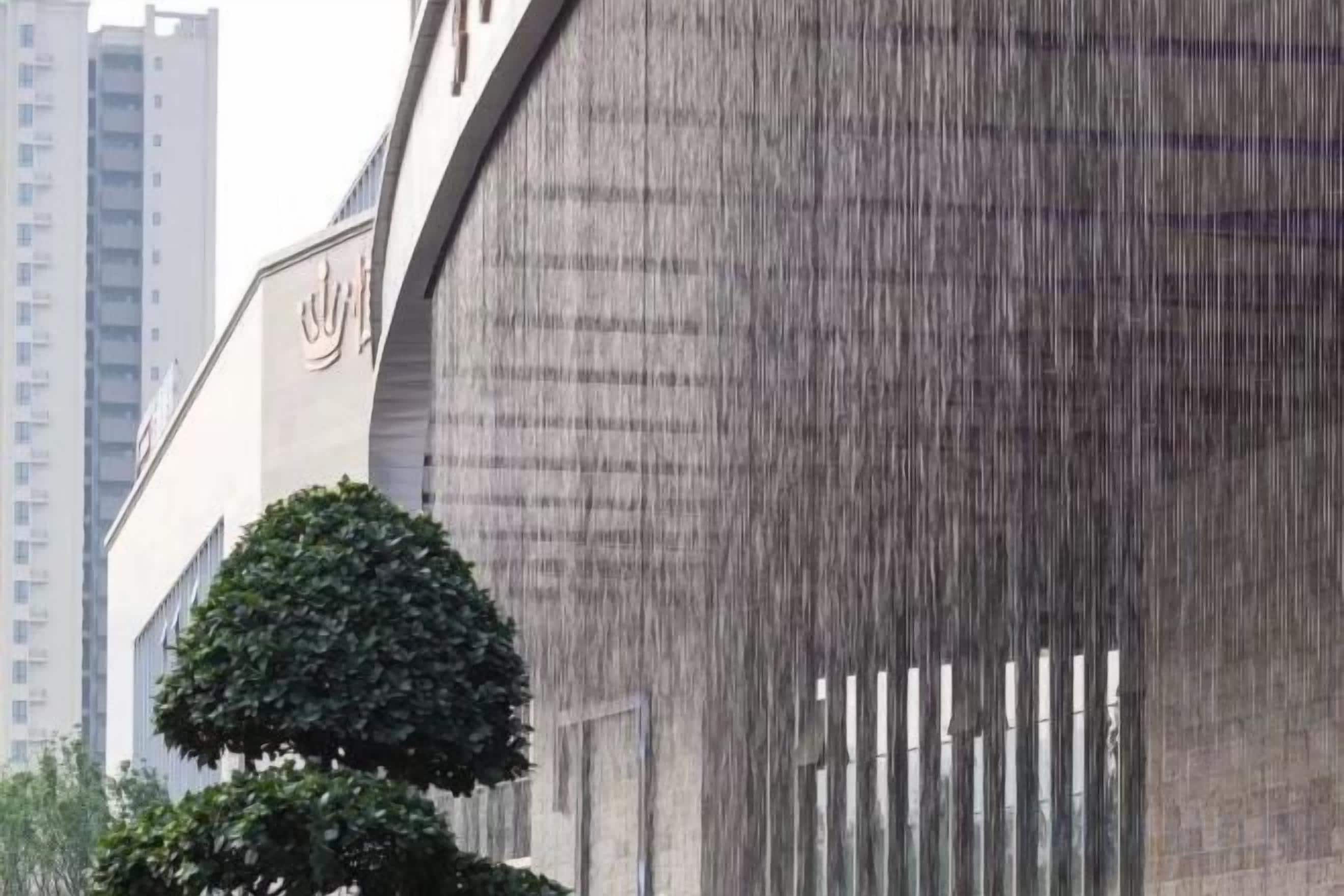 A building with a modern architectural design, featuring a large, curved facade and a prominent logo on the side.