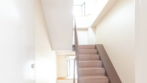 Eine Treppe mit Teppichstufen und Metallgeländern, die zu einer oberen Etage führt.