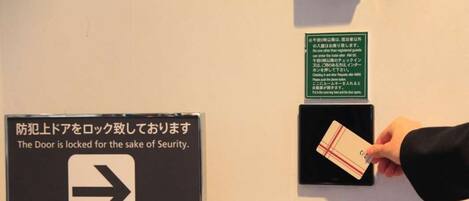 Une chambre d’hôtel avec un panneau indiquant l’emplacement du lecteur de carte d’accès, à des fins de sécurité.