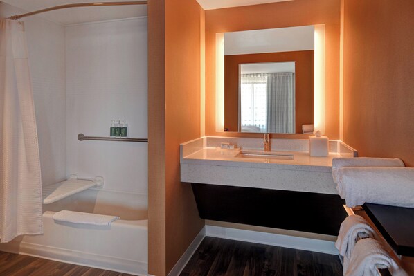 A modern bathroom with a shower, a sink with a mirror, and a bathtub.