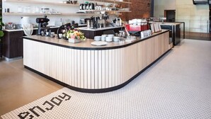 A modern bar area with a curved counter, wooden shelves, and potted plants. - Historic Downtown Loft  with King Bed and Wifi (Spokane)