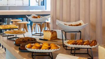 Een buffet met diverse gebakjes en patisserie.