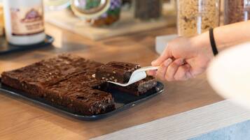 Una persona cortando un brownie en una bandeja.