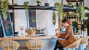 A bar area with a counter, wicker chairs, and a menu board. - ibis budget Rouen Centre Rive Gauche (Rouen)