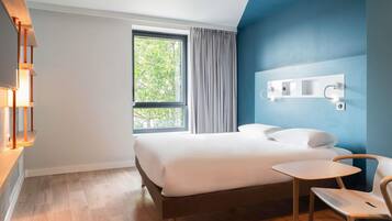 Una habitación de hotel moderna con una cama, un escritorio y una silla.