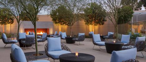 An outdoor seating area with wicker chairs and a fire pit.