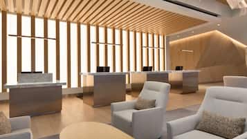 A modern reception area with wooden slatted ceilings, a reception desk, and seating arrangements.