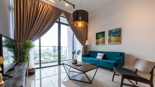 Uma sala de estar moderna com uma janela grande, um sofá azul, uma mesa de centro e uma televisão.