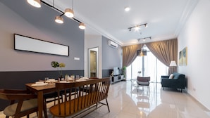 Uma sala de estar moderna com área de refeições, apresentando uma mesa de jantar de madeira, cadeiras e um sofá.