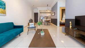 Uma sala de estar moderna com um sofá verde-água, uma mesa de centro de madeira e uma TV sobre um suporte de madeira.