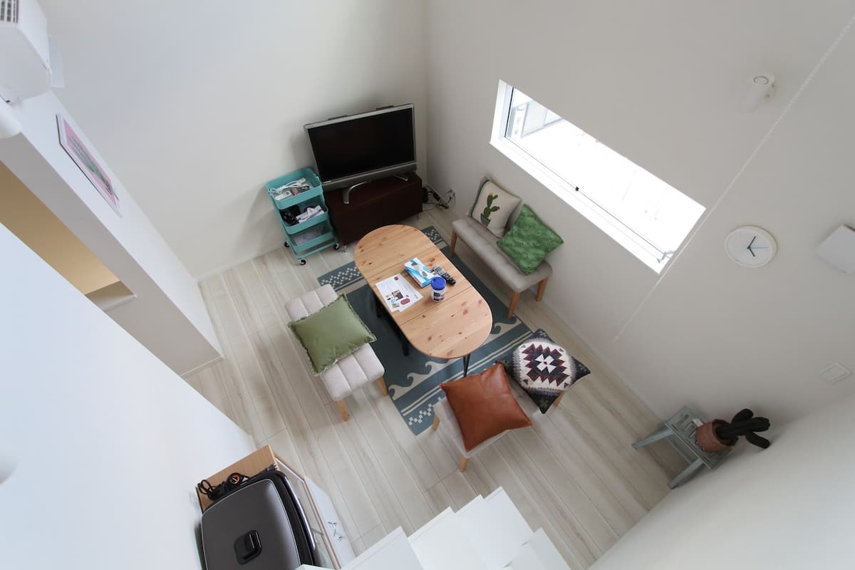 Una sala de estar moderna con un televisor de pantalla plana, una mesa de centro de madera y un sofá.