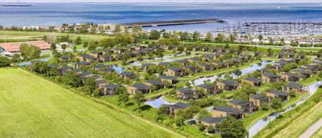 A residential area with modern houses, a marina, and a large body of water.